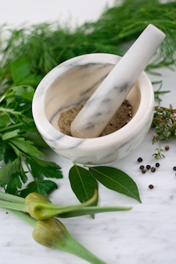 Crushing seeds with a mortar and pestle.